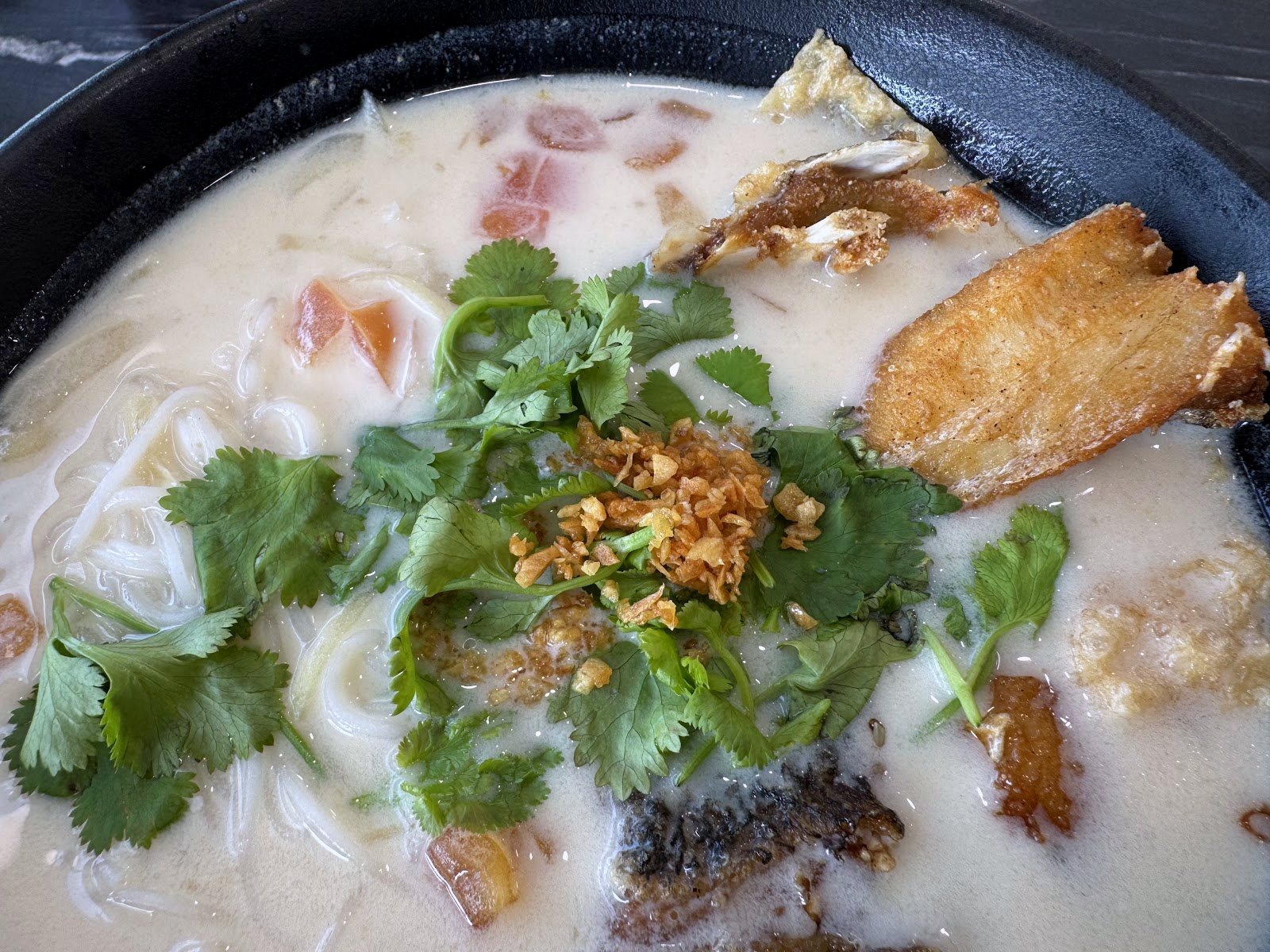 close-up of milky fish head noodle soup